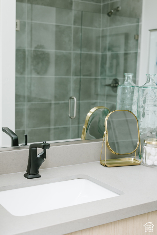 Bathroom view of vanity and a shower with door