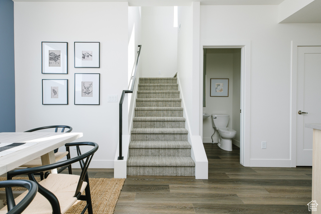 Staircase with wood finished floors and baseboards
