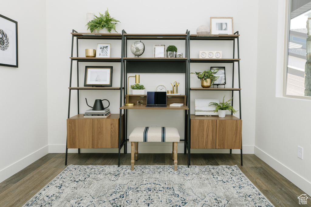 Sitting room featuring dark wood finished floors, baseboards, and an office area