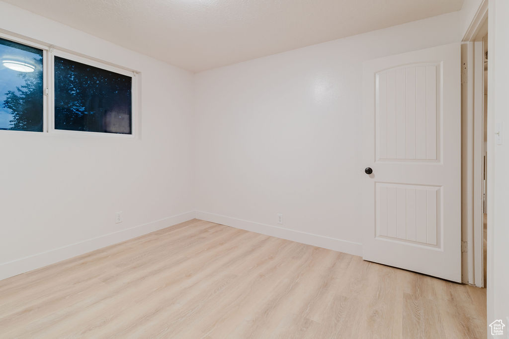 Unfurnished room with wood finished floors and baseboards
