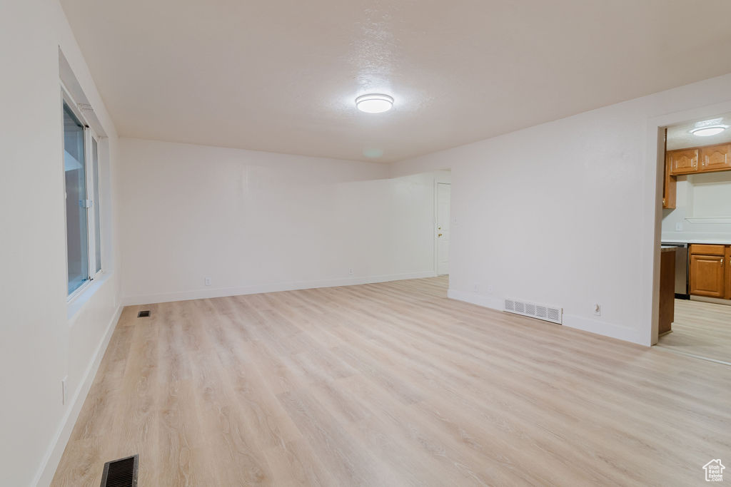 Spare room featuring light wood-style floors and baseboards