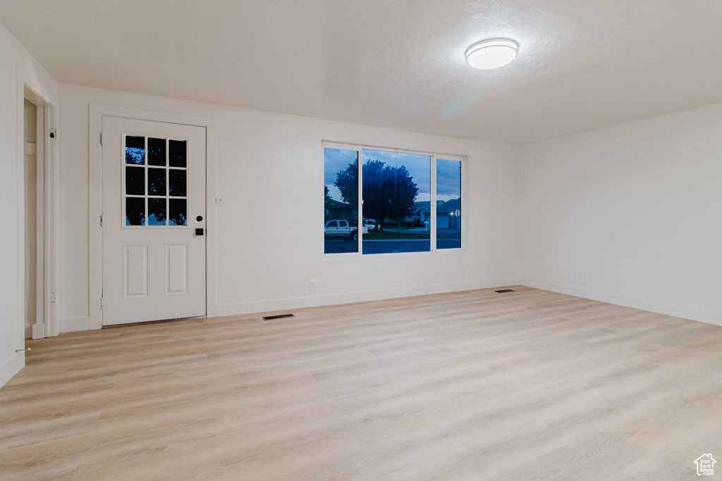 Unfurnished room with light wood-type flooring and baseboards
