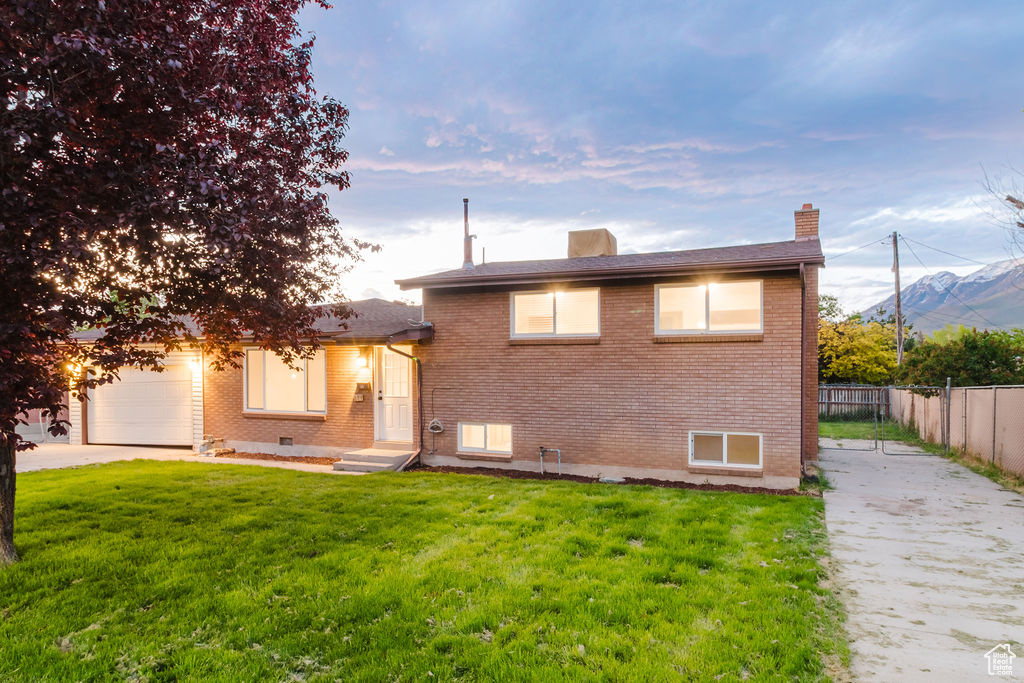 View of front facade with concrete driveway, brick siding, and an attached garage