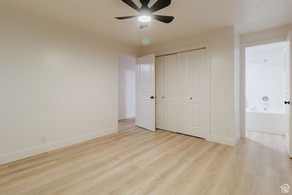 Unfurnished bedroom featuring wood finished floors, baseboards, a closet, and a ceiling fan