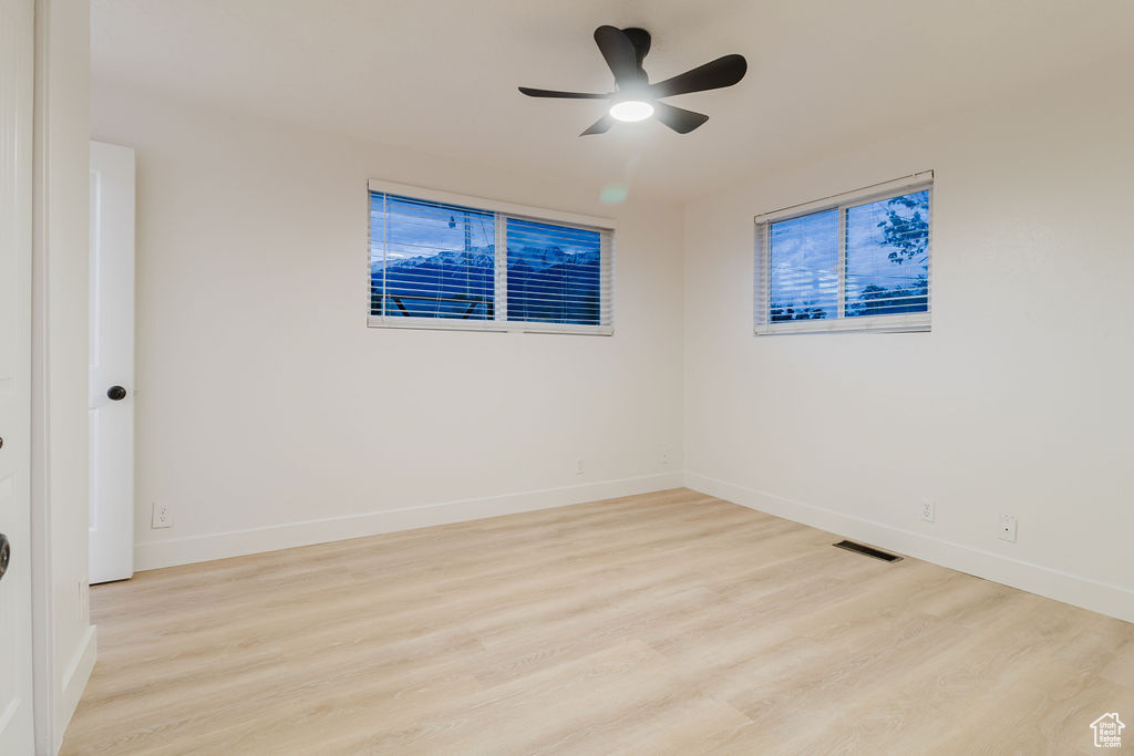 Spare room featuring wood finished floors, baseboards, and a ceiling fan