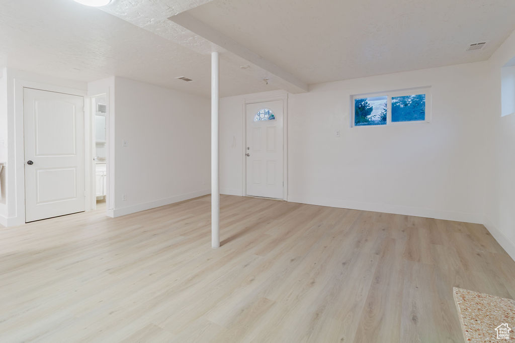 Basement featuring light wood-style flooring and baseboards
