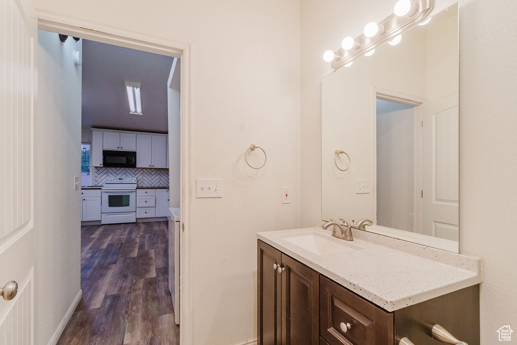 Bathroom with vanity, tasteful backsplash, and wood finished floors
