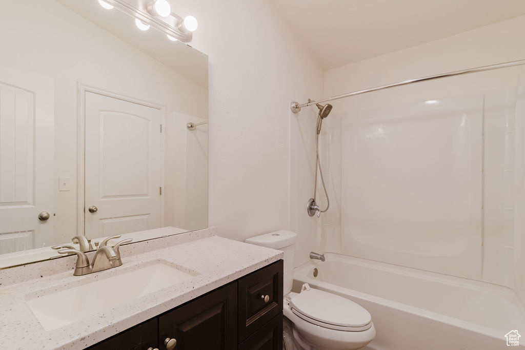 Bathroom with toilet, vanity, and bathtub / shower combination