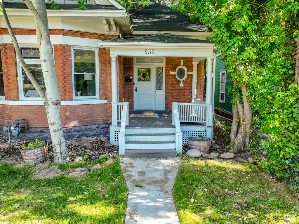 Property entrance with brick siding and covered porch