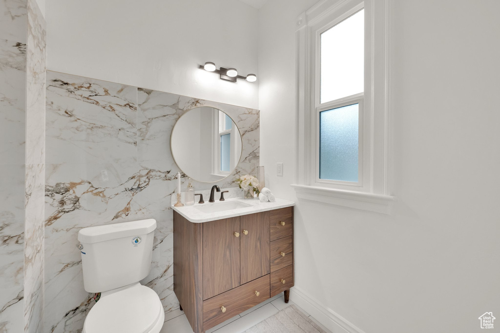 Half bathroom with plenty of natural light, vanity, and toilet