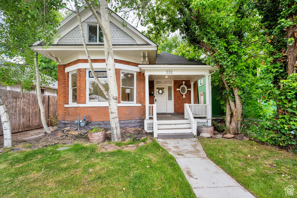View of front of house featuring brick siding and covered porch