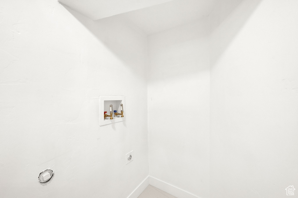 Laundry area with electric dryer hookup, hookup for a washing machine, and baseboards