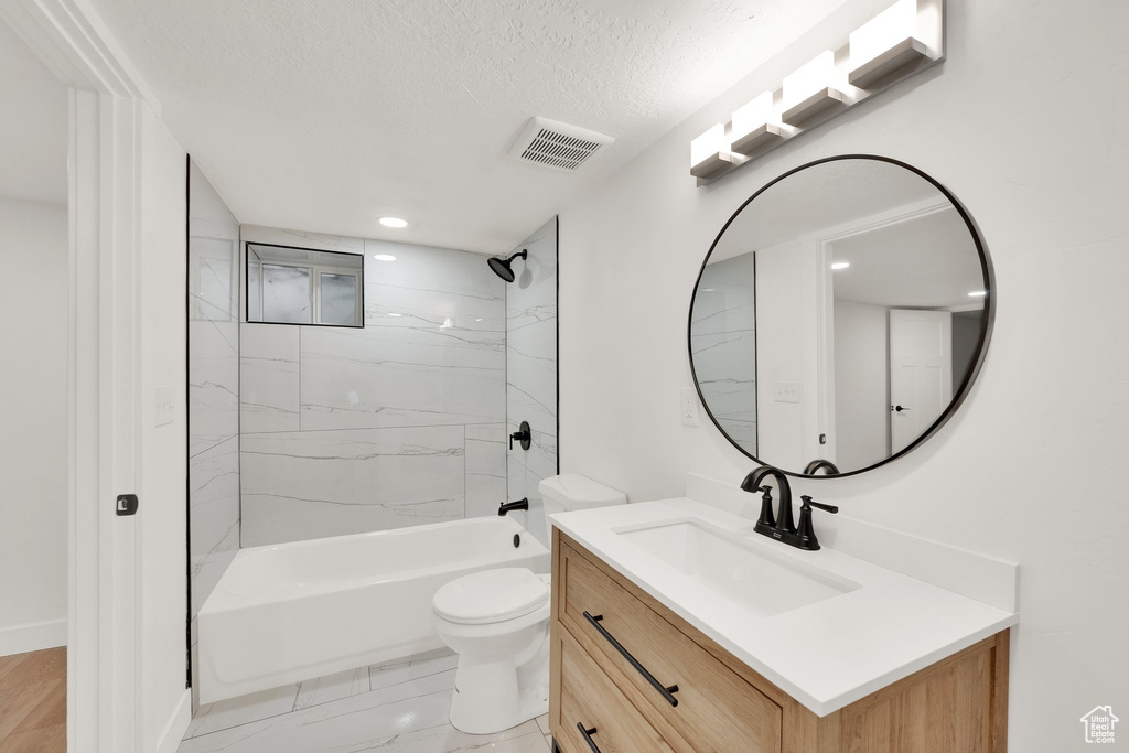 Bathroom featuring vanity, toilet, bathtub / shower combination, a textured ceiling, and recessed lighting