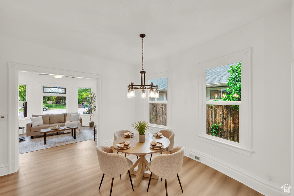 Dining area with light wood-style flooring, baseboards, and a chandelier
