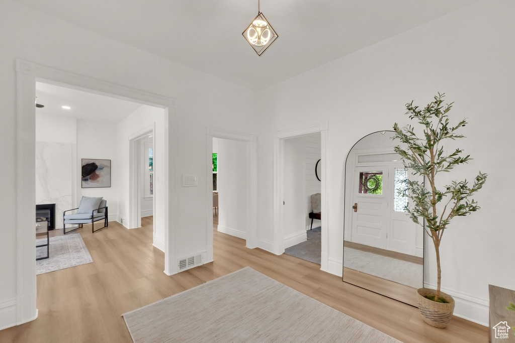 Unfurnished living room featuring light wood finished floors and baseboards