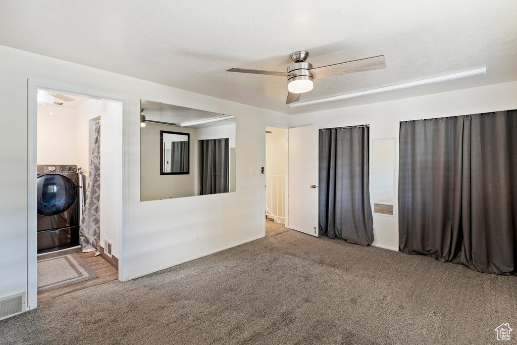 Spare room featuring washer / dryer, ceiling fan, and carpet flooring