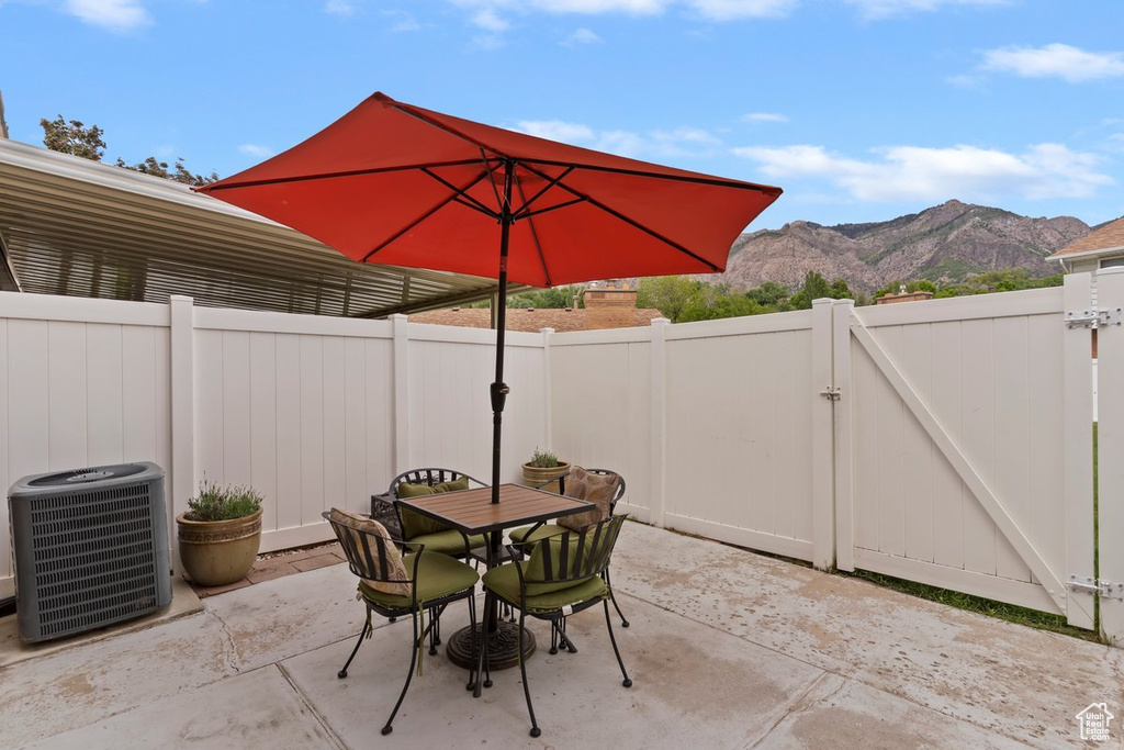 Fenced backyard with a mountain view, a gate, central AC, and a patio area