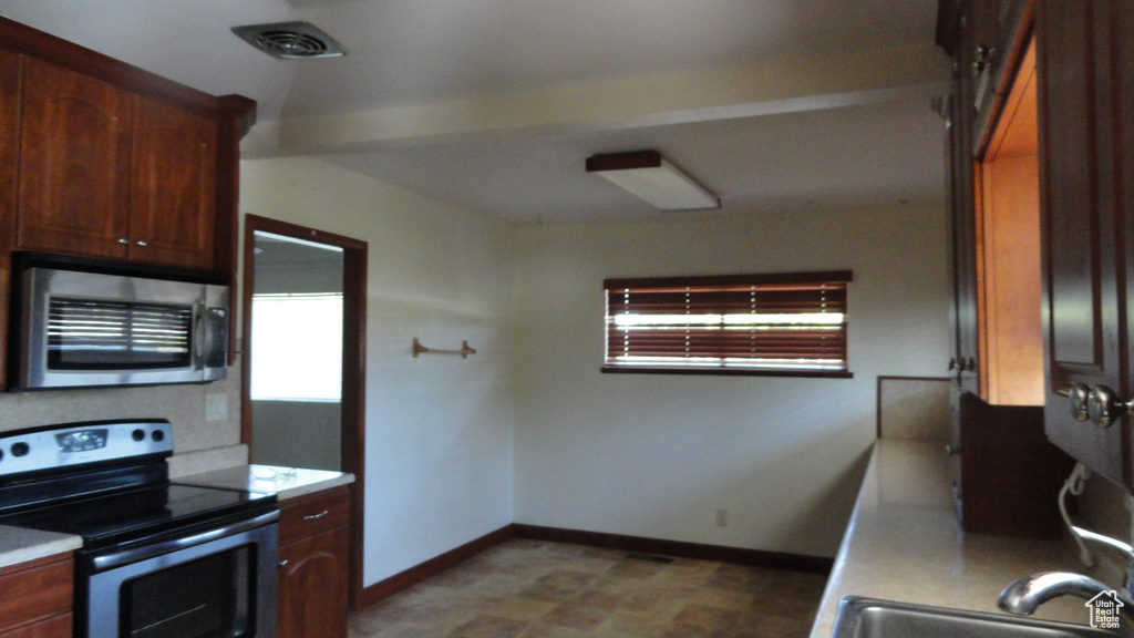 Kitchen with appliances with stainless steel finishes and light countertops