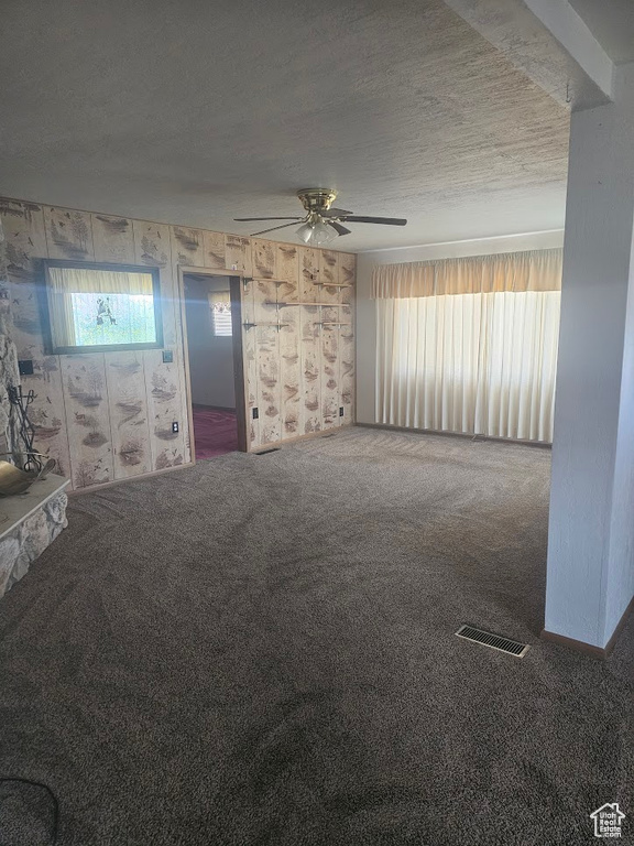 Unfurnished living room featuring carpet and a ceiling fan