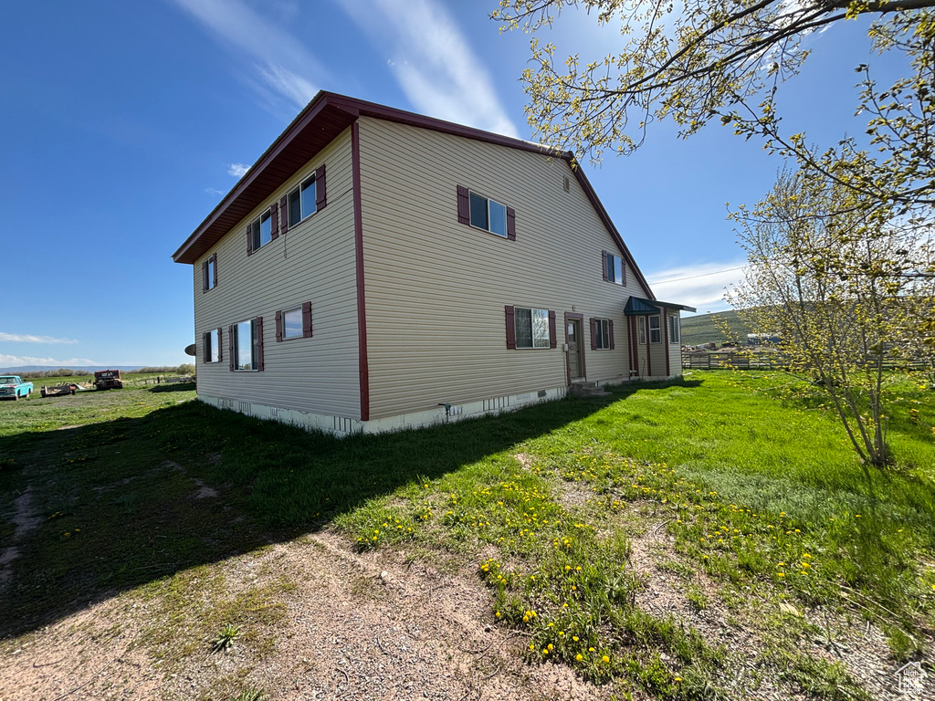 View of side of property featuring a yard