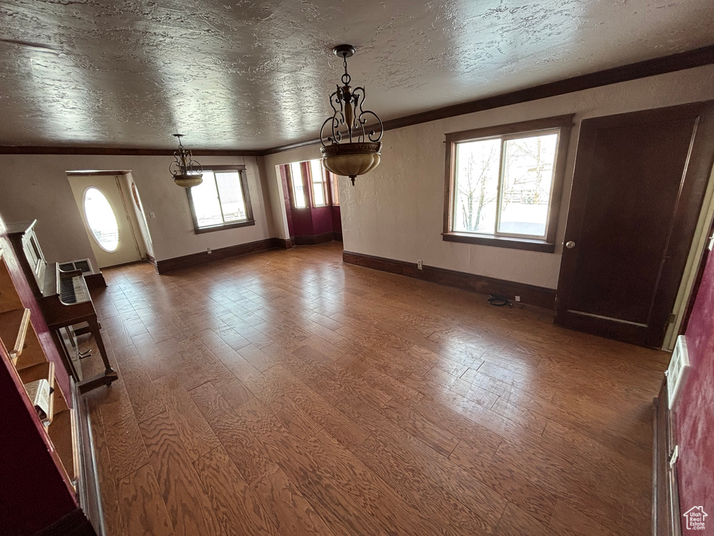 Unfurnished dining area with ornamental molding, wood finished floors, and baseboards