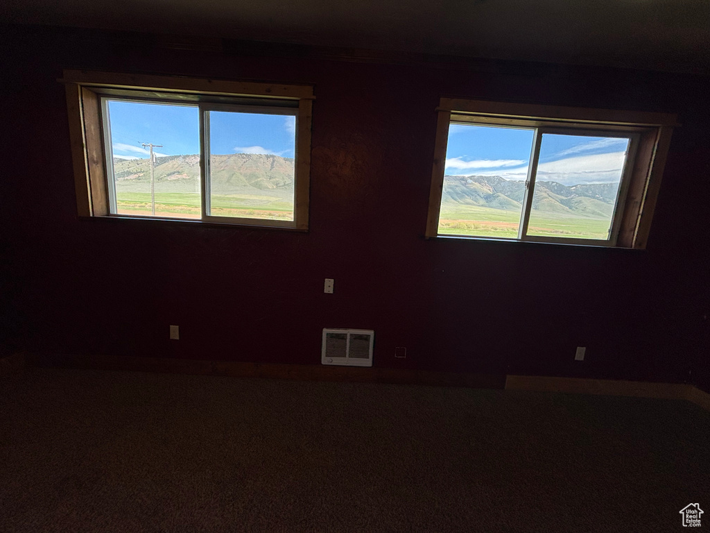 Unfurnished room featuring plenty of natural light and baseboards