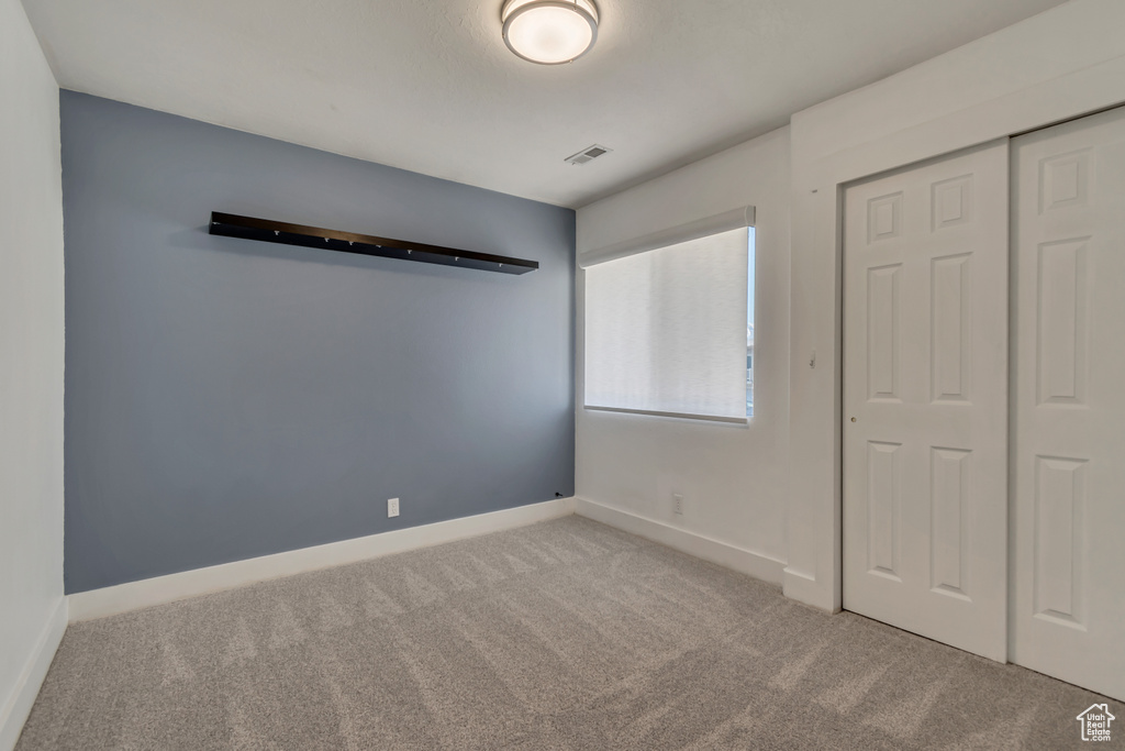 Unfurnished bedroom with carpet floors, a closet, and baseboards