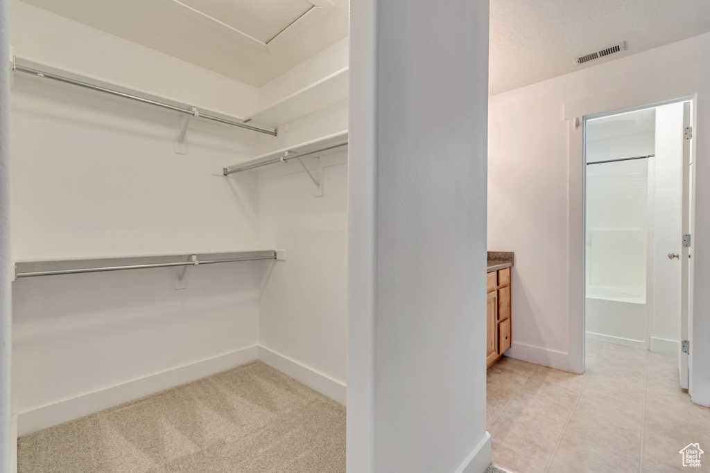 Walk in closet with light tile patterned flooring