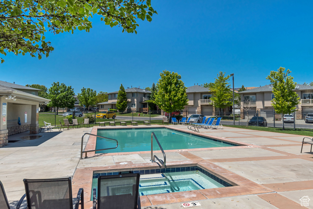 Community pool featuring a residential view, a patio area, and a hot tub