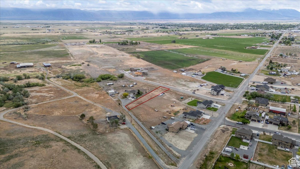 Aerial view of property's location featuring a mountain backdrop and rural landscape