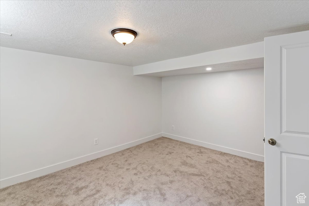 Spare room with carpet floors, baseboards, a textured ceiling, and recessed lighting