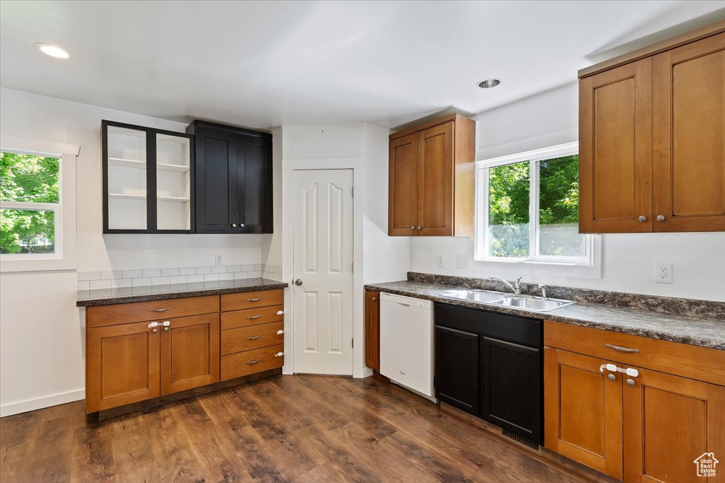 Kitchen with dishwasher, a sink, plenty of natural light, dark countertops, and recessed lighting