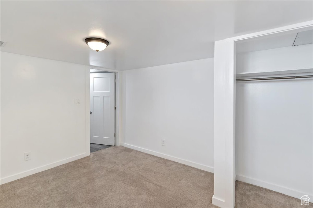 Unfurnished bedroom with carpet flooring, baseboards, and a closet