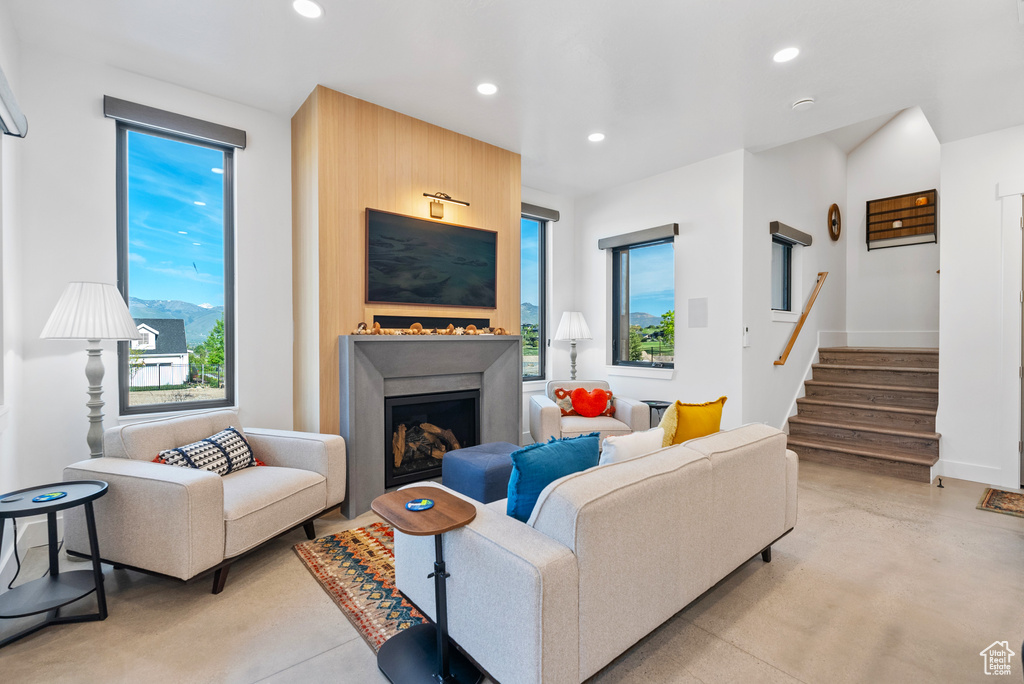 Living area with recessed lighting, stairs, a fireplace, concrete floors, and baseboards