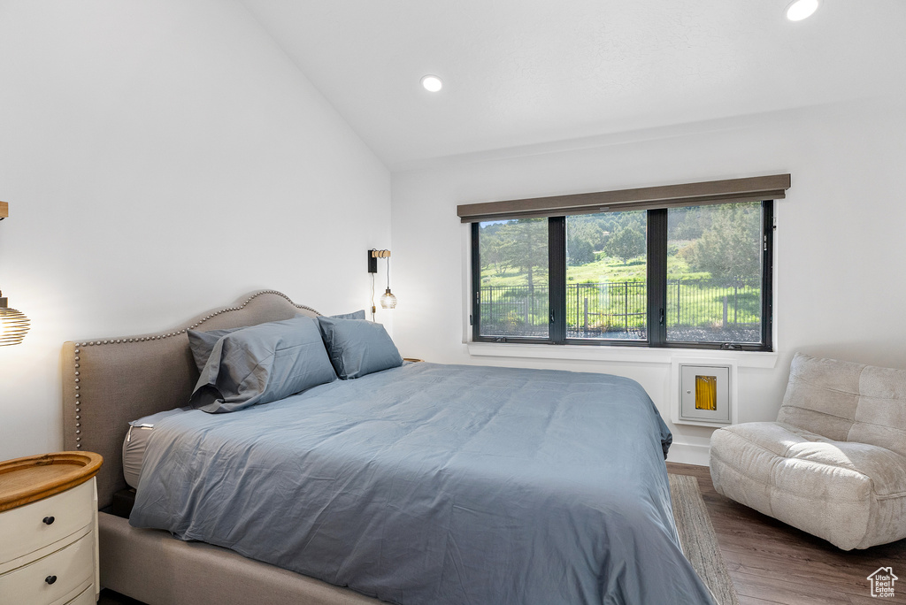 Bedroom with wood finished floors, lofted ceiling, and recessed lighting