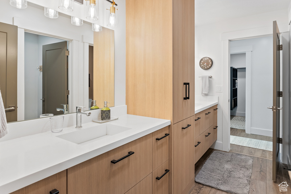 Bathroom with wood finished floors, vanity, and baseboards
