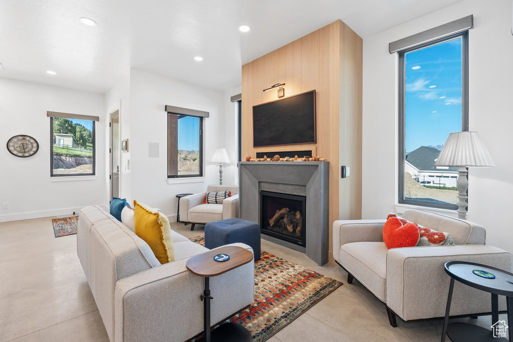 Living area featuring a fireplace, recessed lighting, and baseboards