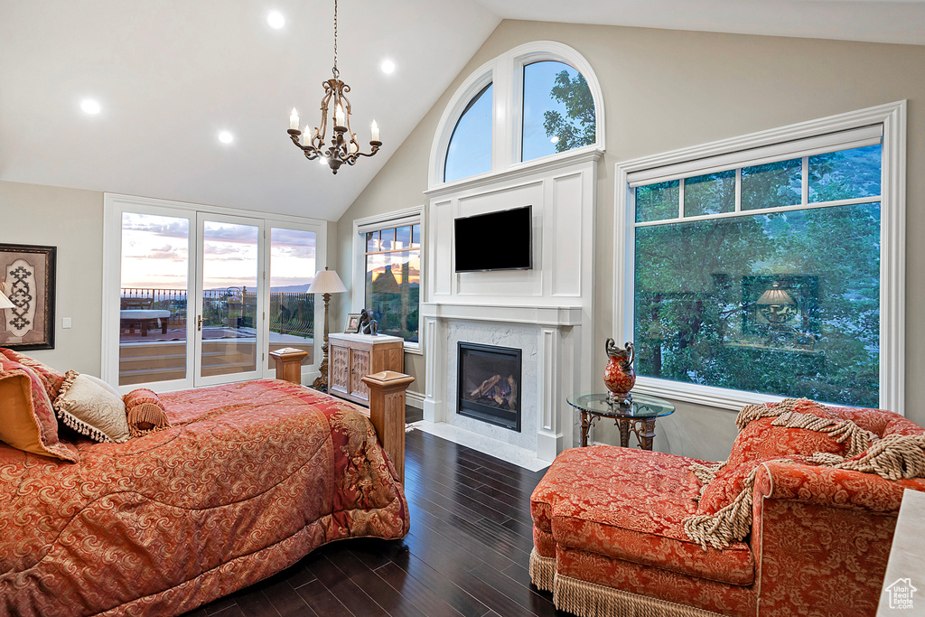 Bedroom featuring dark wood finished floors, a chandelier, access to exterior, recessed lighting, and a fireplace
