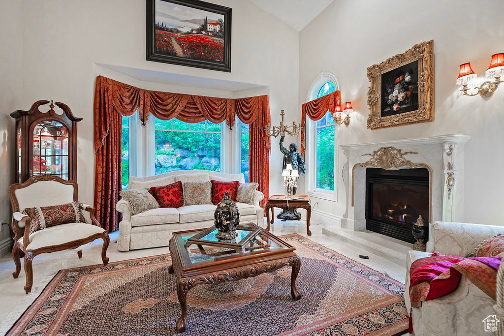 Living room featuring high vaulted ceiling, a fireplace, and baseboards