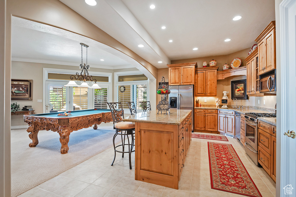 Kitchen featuring stainless steel appliances, recessed lighting, a center island, light tile patterned floors, and a breakfast bar area