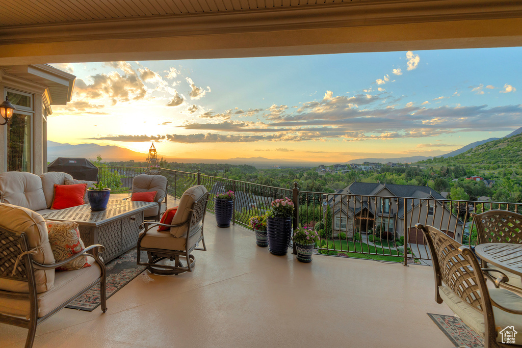 View of patio with a mountain view, a grill, and a balcony