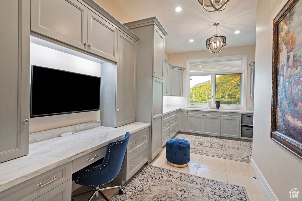 Home office featuring built in study area, light tile patterned floors, recessed lighting, a chandelier, and baseboards