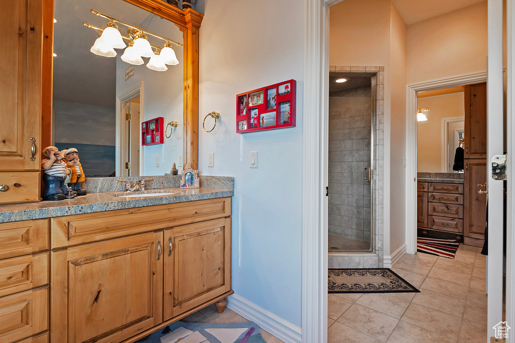 Full bath with vanity, a stall shower, baseboards, and tile patterned flooring