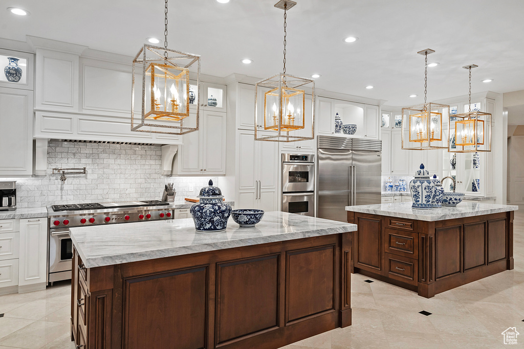 Kitchen with a kitchen island, a chandelier, premium appliances, backsplash, and recessed lighting