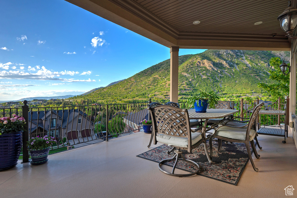 View of patio with a mountain view, a balcony, and outdoor dining space