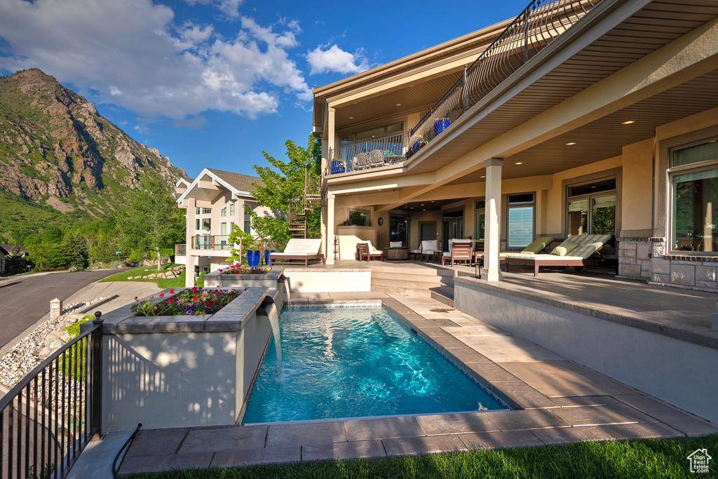 Outdoor pool featuring an outdoor living space, a patio, and a mountain view