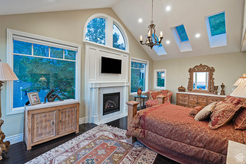 Bedroom featuring a skylight, wood finished floors, a chandelier, high vaulted ceiling, and recessed lighting