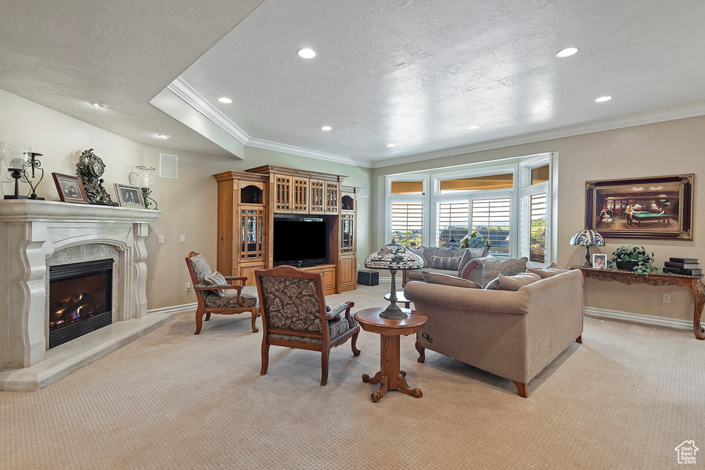 Living room with light colored carpet, crown molding, a fireplace, recessed lighting, and baseboards