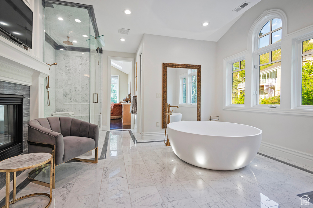 Full bath featuring marble tiled flooring, a shower stall, baseboards, a soaking tub, and recessed lighting