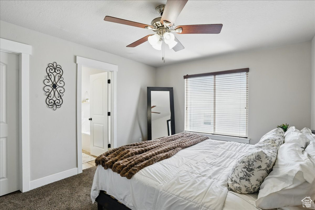 Bedroom featuring carpet flooring, baseboards, ceiling fan, and ensuite bath